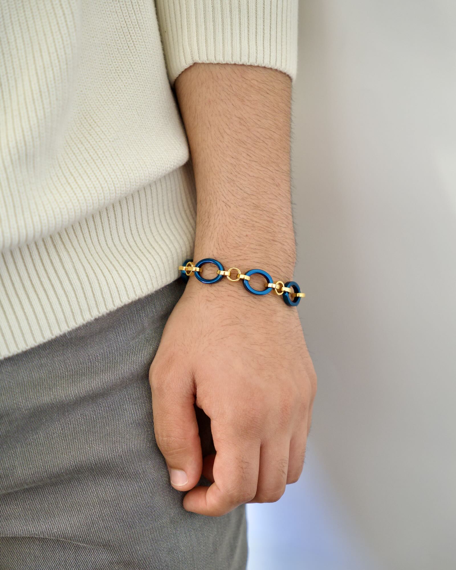 Men's wrist wearing Meridian Chain Bracelet in Midnight Gold, deep blue titanium & 18K yellow gold PVD - hand relaxed down