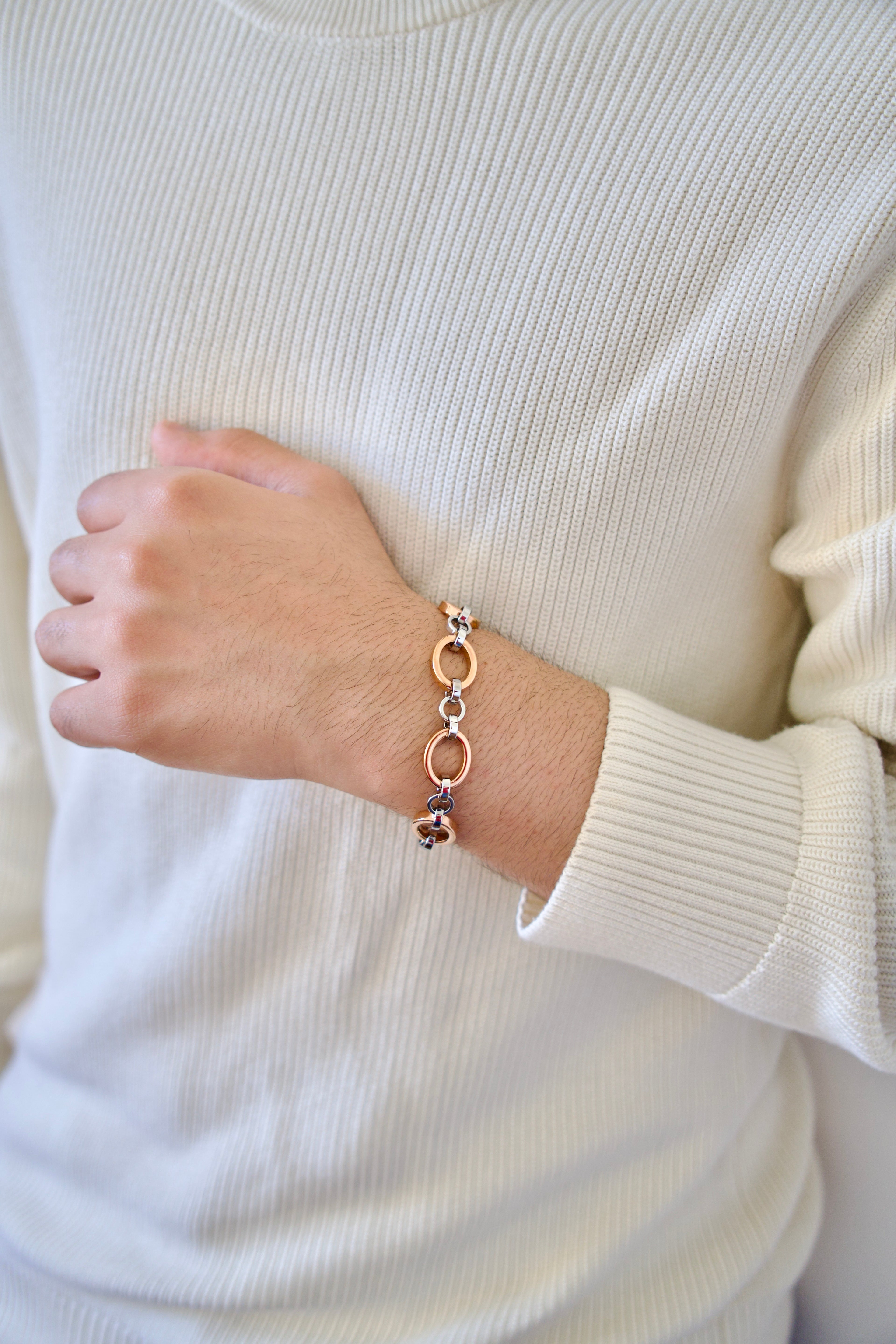 Man wearing a rose gold and white gold bracelet on a white sweater
