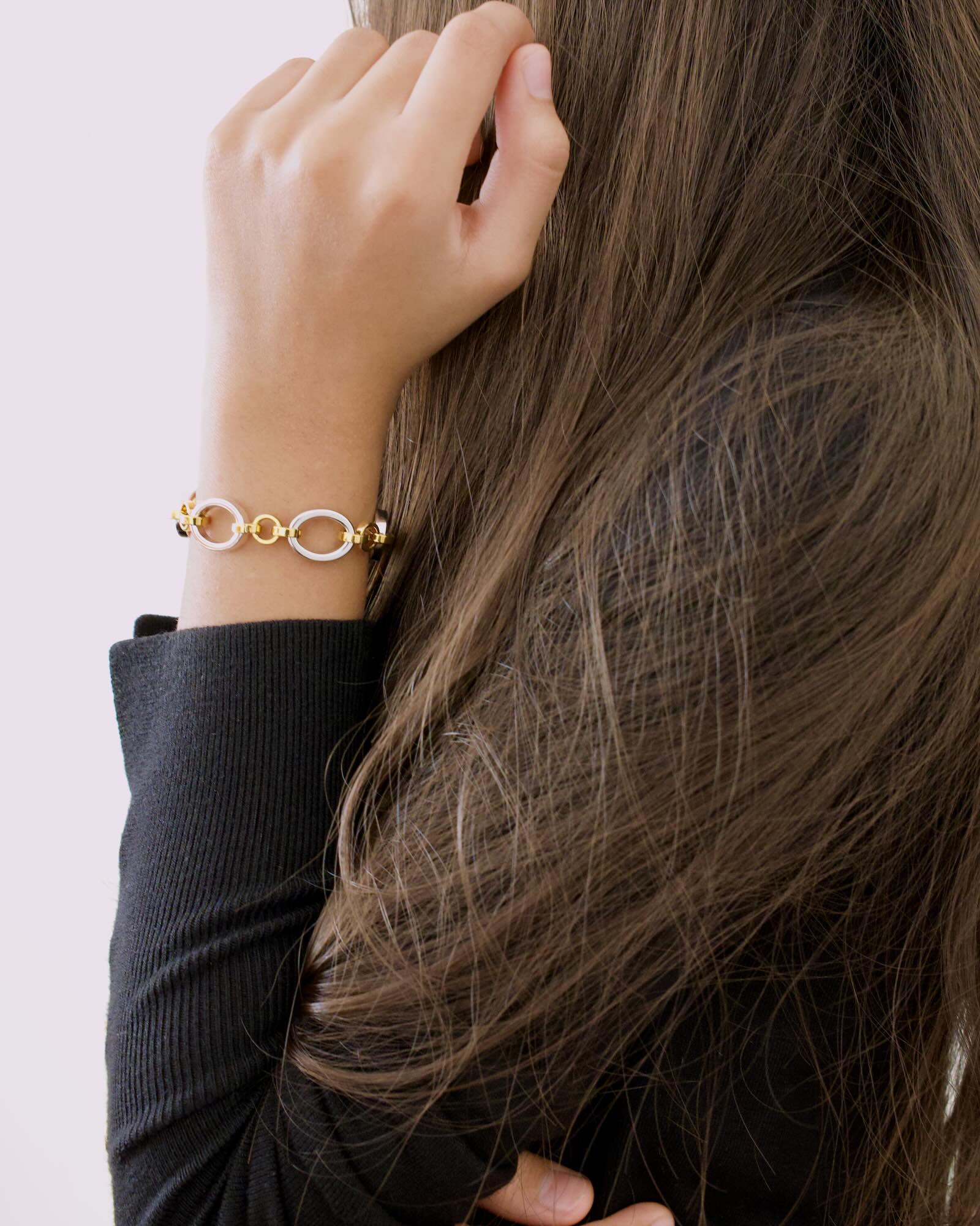 Women's wrist wearing Meridian Chain Bracelet in Twilight, 18K white & yellow gold PVD stainless steel - arm raised, side profile shot