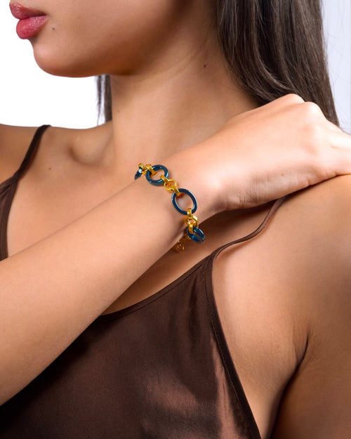 Women's wrist wearing Meridian Chain Bracelet in Midnight Gold, deep blue titanium & 18K yellow gold PVD, studio shot - hand resting on shoulder
