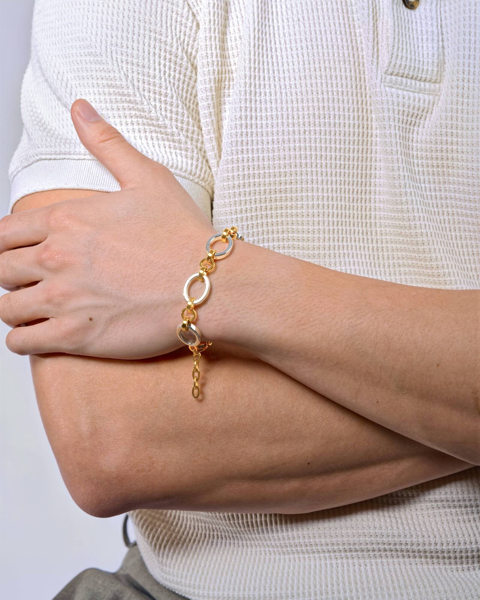 Men's wrist wearing Meridian Chain Bracelet in Twilight, 18K white & yellow gold PVD stainless steel, studio shot - hands crossed