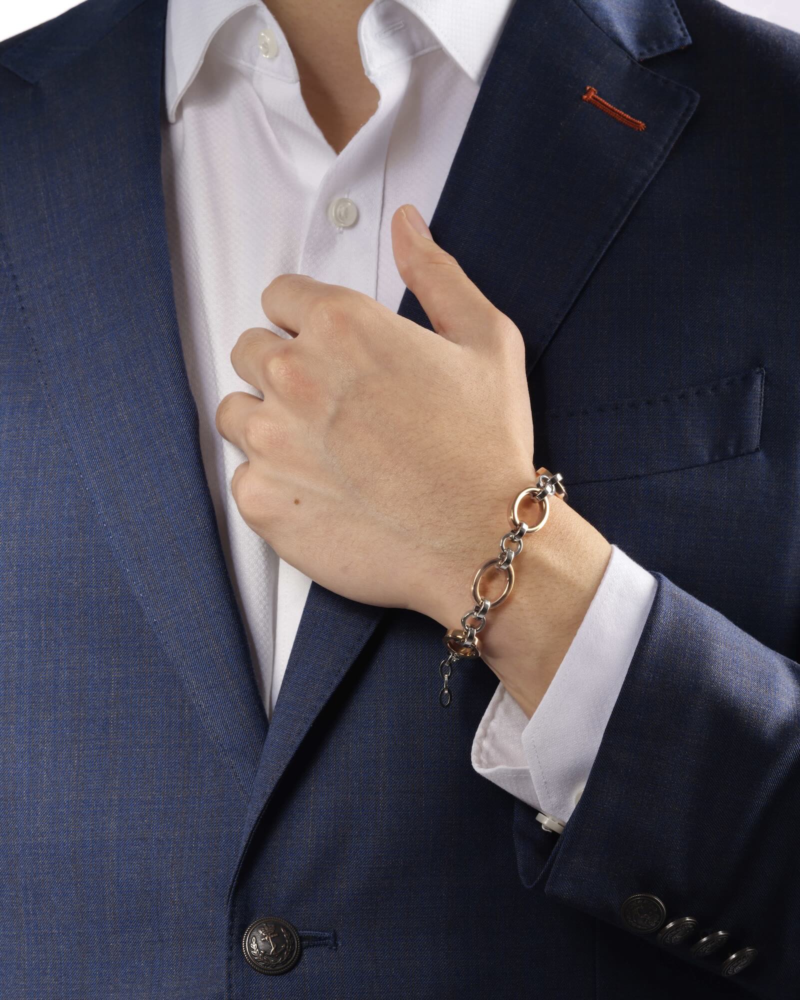 Men's wrist wearing Meridian Chain Bracelet in Frosty Rose, 18K rose & white gold PVD stainless steel, studio shot - hand raised holding suit jacket lapel